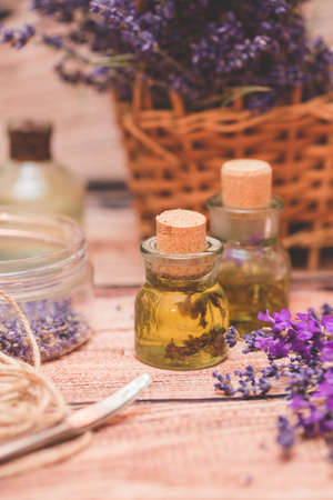 Lavender oil with fresh flowers on wooden background.の写真素材