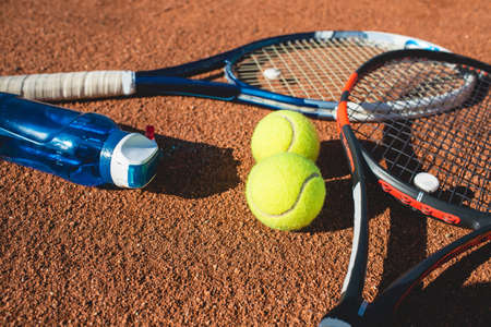 Tennis balls and rackets on the court