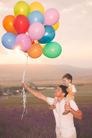 Father and son playing with balloons on lavender fieldの写真素材