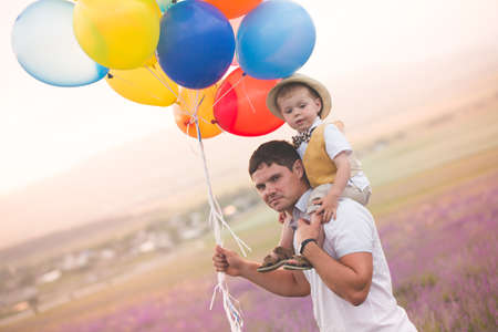 Father and son playing with balloons on lavender fieldの写真素材