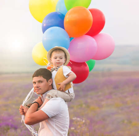 Father and son playing with balloons on lavender fieldの写真素材