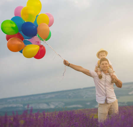 Father and son playing with balloons on lavender fieldの写真素材
