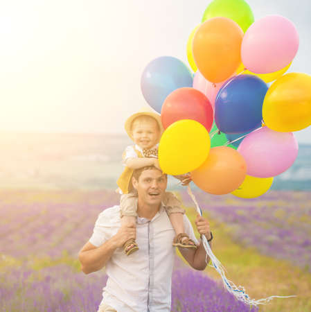 Father and son playing with balloons on lavender fieldの写真素材