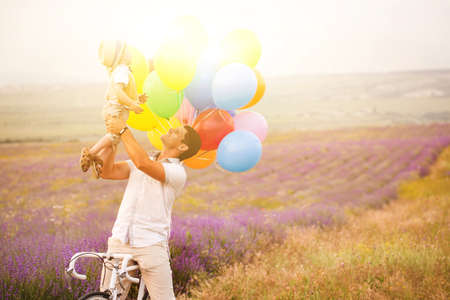 Father and son playing with balloons on lavender fieldの写真素材