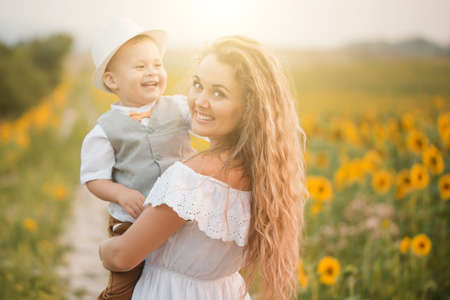 Mother with baby son in sunflower fieldの写真素材