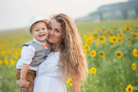 Mother with baby son in sunflower fieldの写真素材