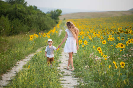 Mother with baby son in sunflower fieldの写真素材