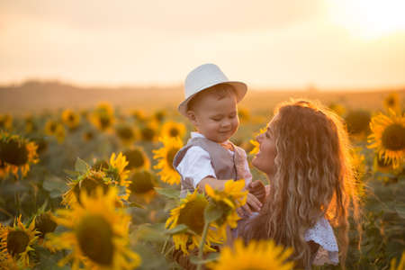 Mother with baby son in sunflower fieldの写真素材