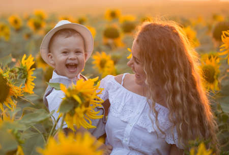 Mother with baby son in sunflower fieldの写真素材