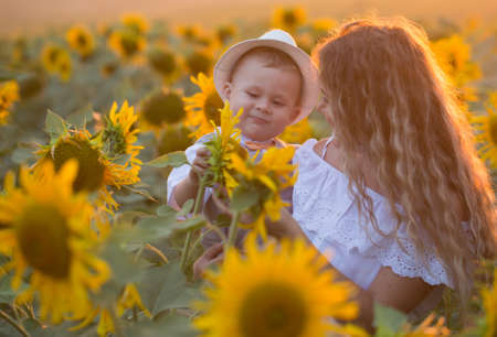 Mother with baby son in sunflower field