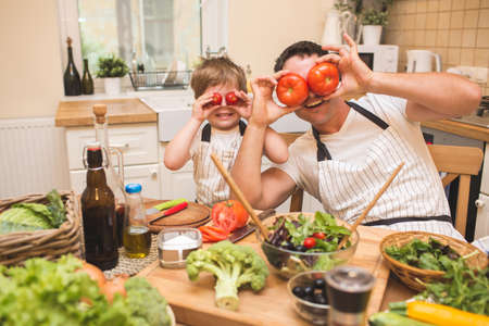 Chef man cooking on the kitchen with little son.の写真素材
