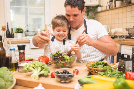 Chef man cooking on the kitchen with little son.の写真素材