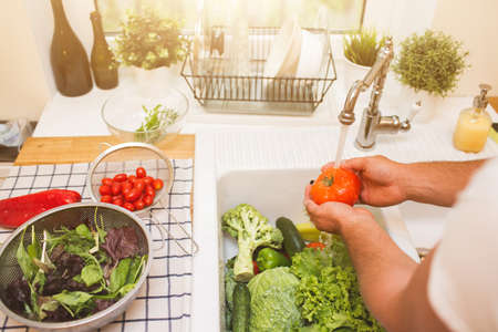 Man washes vegetables before eatingの写真素材