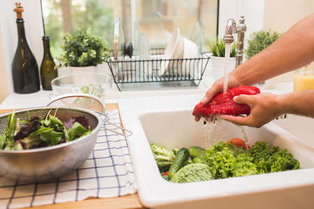 Man washes vegetables before eatingの写真素材