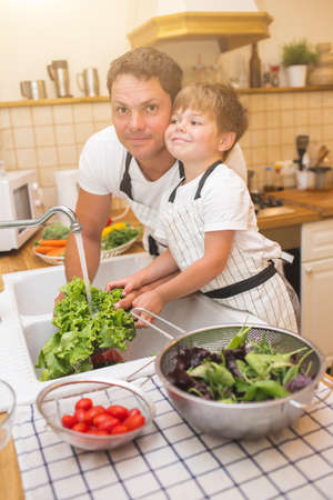 Father with son washes vegetables before eatingの写真素材