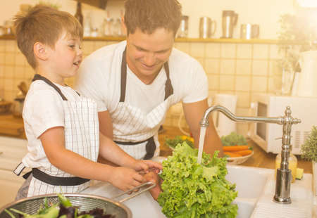 Father with son washes vegetables before eatingの写真素材