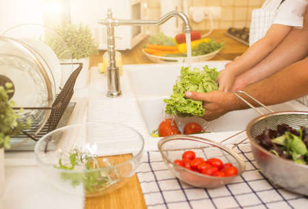 Father with son washes vegetables before eatingの写真素材