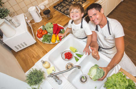 Father with son washes vegetables before eatingの写真素材