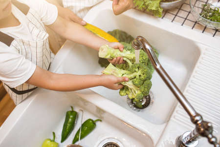 Father with son washes vegetables before eatingの写真素材