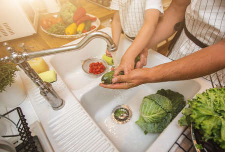 Father with son washes vegetables before eatingの写真素材