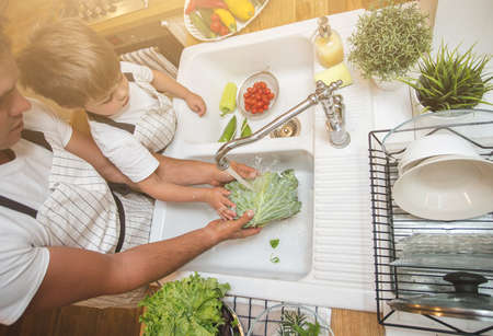 Father with son washes vegetables before eatingの写真素材