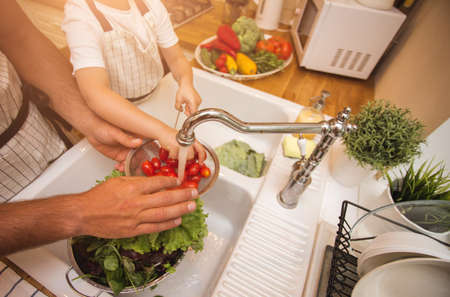 Father with son washes vegetables before eatingの写真素材