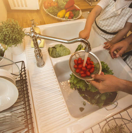 Father with son washes vegetables before eatingの写真素材