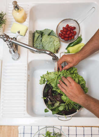 Man washes vegetables before eatingの写真素材