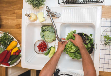 Man washes vegetables before eatingの写真素材