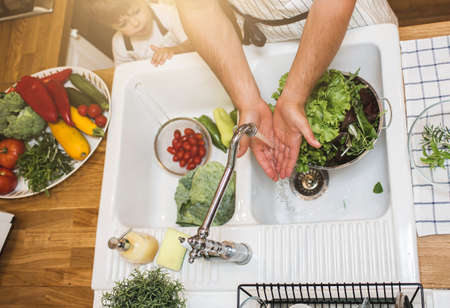 Father with son washes vegetables before eatingの写真素材