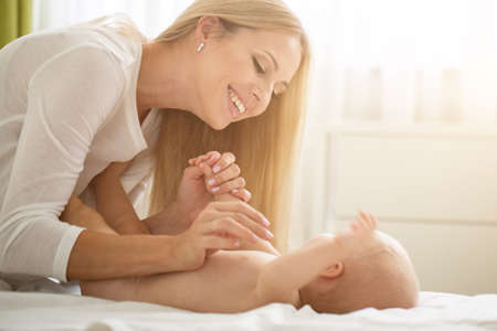 Portrait of young beautiful mother with baby sonの写真素材
