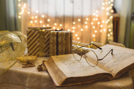 Holy bible book with eyeglasses. Christmas lights on background.の写真素材