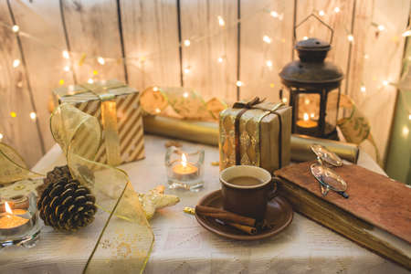 Old book with eyeglasses. Christmas decoration on background. Cup of coffeeの写真素材