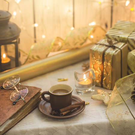 Old book with eyeglasses. Christmas decoration on background. Cup of coffeeの写真素材