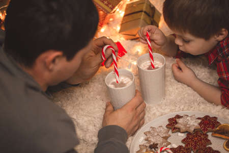 Father and son laying under christmas tree.の写真素材