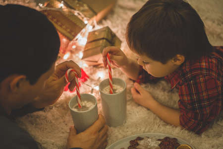 Father and son laying under christmas tree.の写真素材