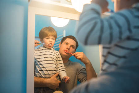 Young father with his son brushing teethの写真素材