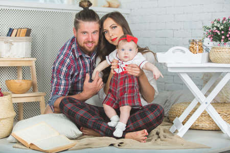 Happy young family mother, father and daughter playing on carpet at home.の写真素材
