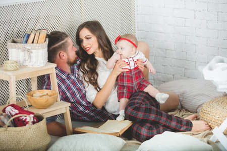Happy young family mother, father and daughter playing on carpet at home.の写真素材