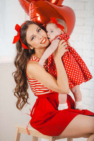 Happy young family mother and daughter posing in studio.の写真素材