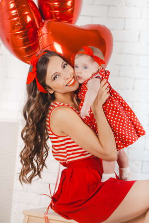Happy young family mother and daughter posing in studio.の写真素材