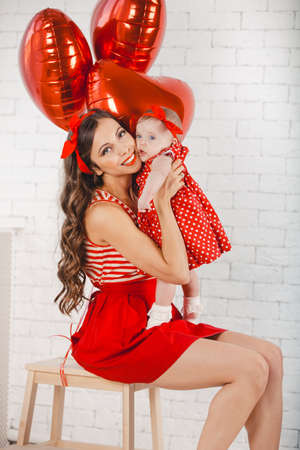 Happy young family mother and daughter posing in studio.の写真素材