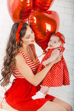 Happy young family mother and daughter posing in studio.の写真素材