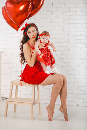 Happy young family mother and daughter posing in studio.の写真素材