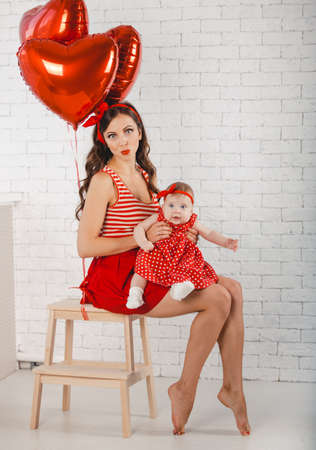 Happy young family mother and daughter posing in studio.の写真素材