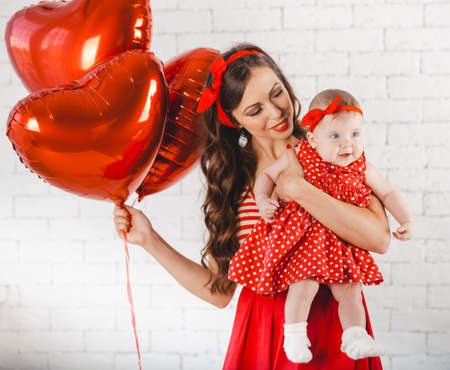 Happy young family mother and daughter posing in studio.の写真素材
