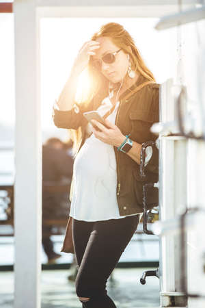 Beautiful young pregnant woman portrait on ferry boatの写真素材