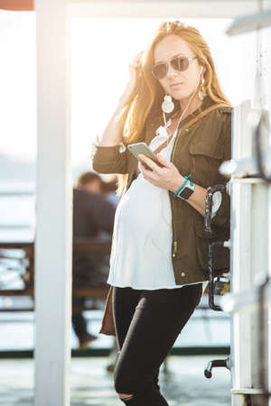 Beautiful young pregnant woman portrait on ferry boatの写真素材