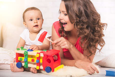 A young mother and son having fun together at homeの写真素材