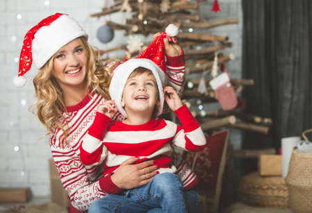 Portrait of happy mother and son on the background of the Christmas tree in new year room. The idea for postcardsの写真素材
